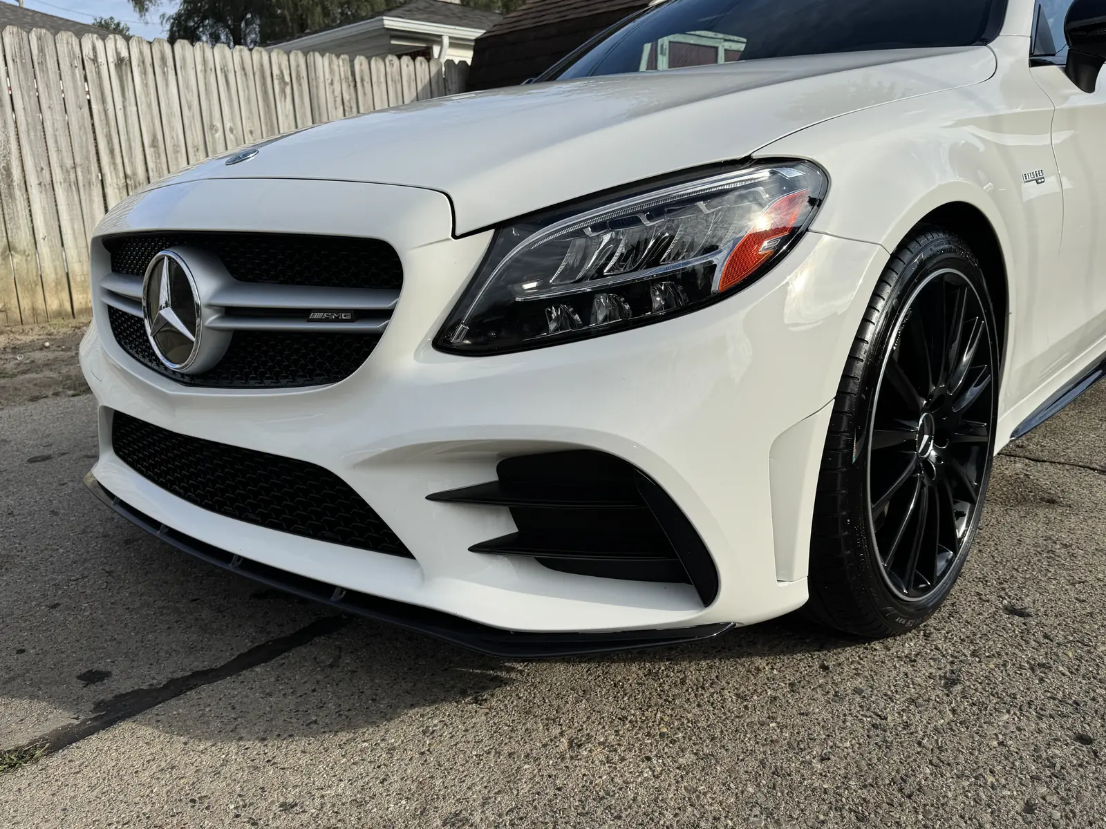 White Mercedes-AMG coupe with black wheels in a driveway