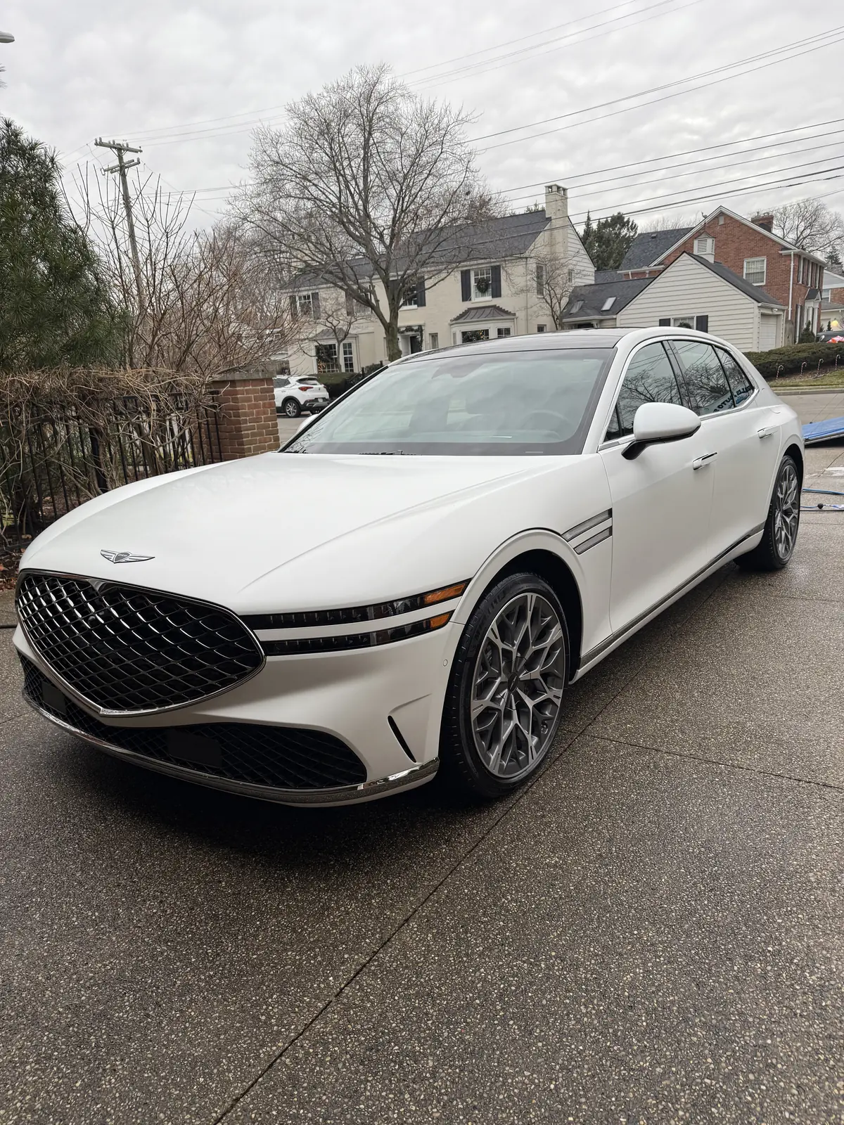 White Genesis G90 sedan parked on a residential street