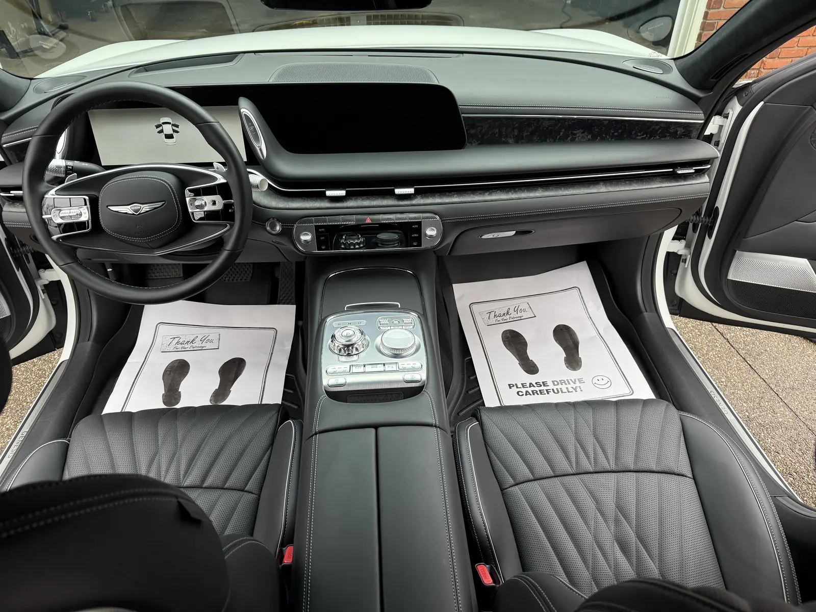 Genesis G90 front cabin with black leather and protective paper floor mats