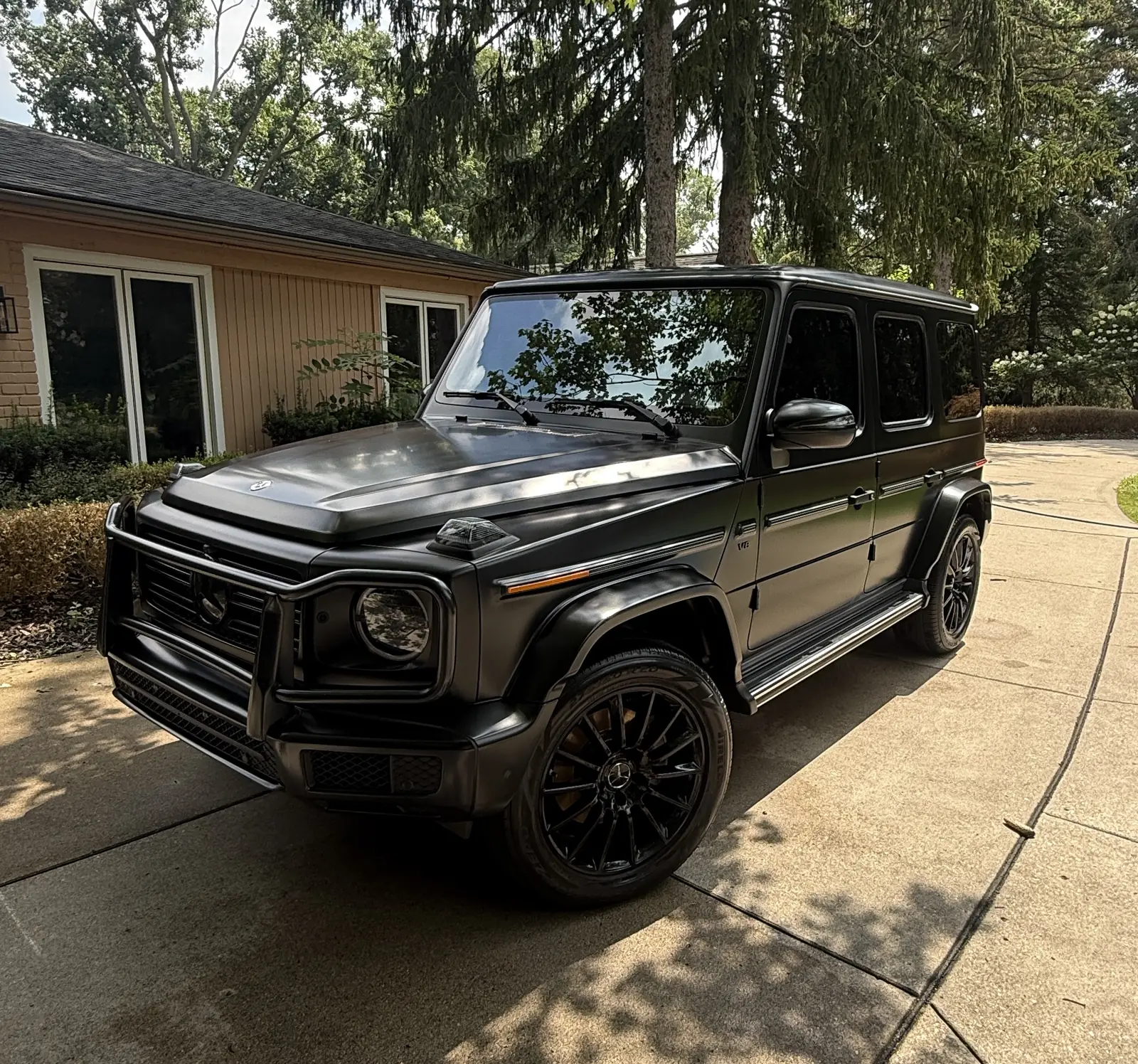 Black Mercedes G-Class in a shaded driveway