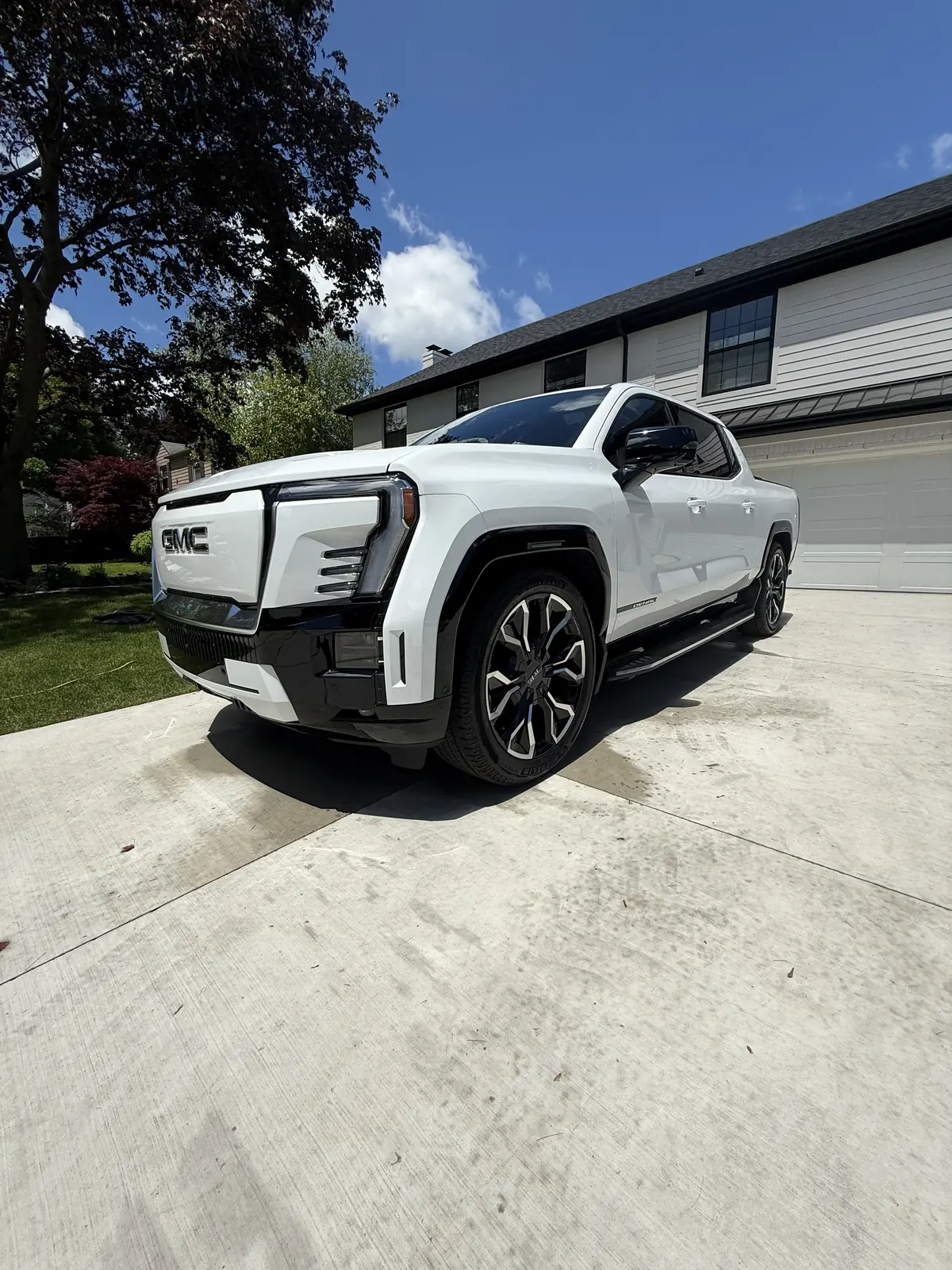 White GMC Sierra EV pickup in a driveway