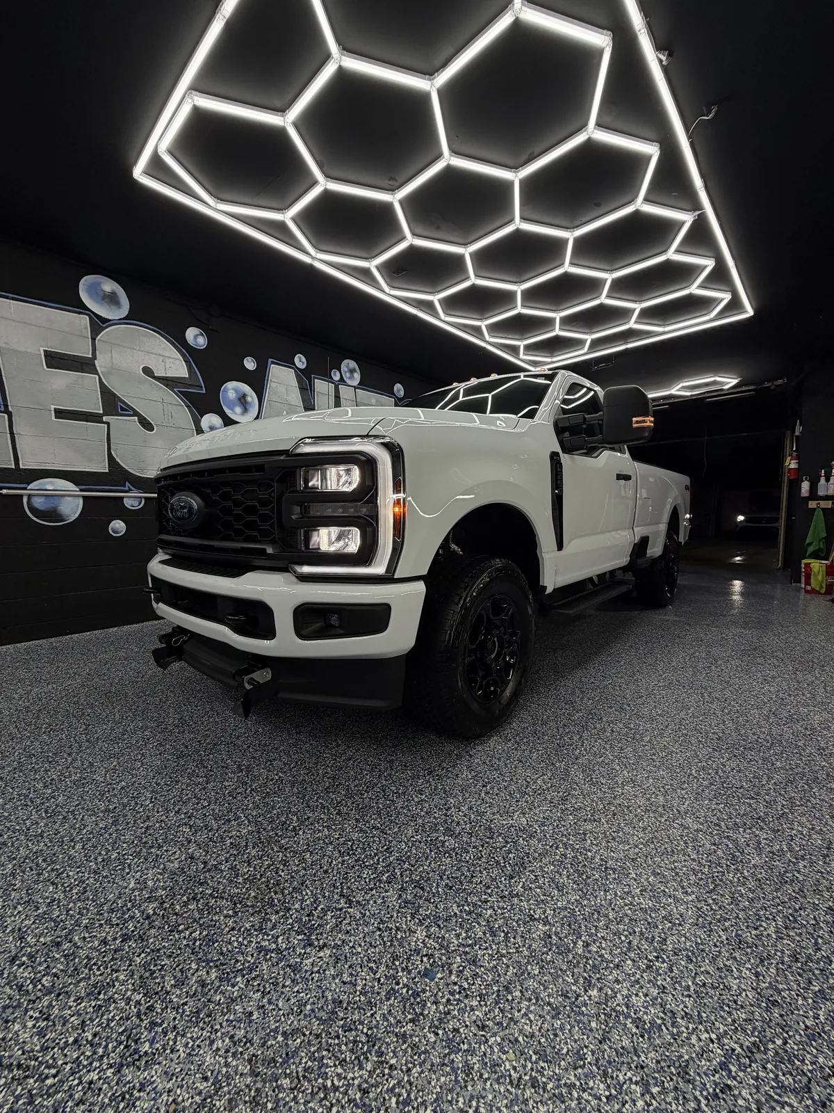 White Ford Super Duty pickup under the hexagonal lights in the studio